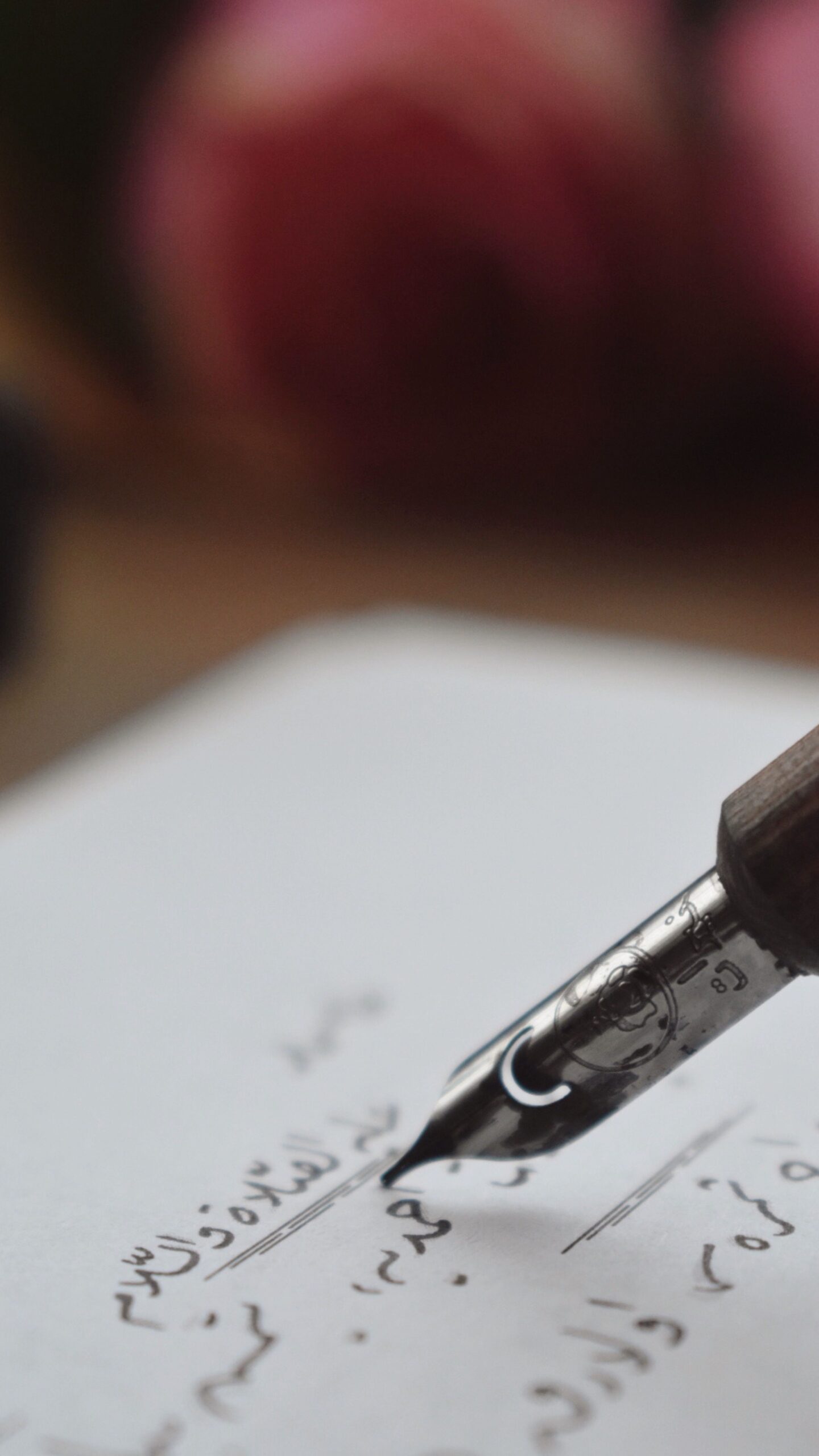 Escritura Close-up of a fountain pen writing elegant calligraphy on paper.
